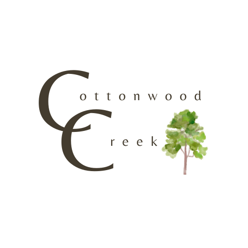 A logo with a tree and the words "Cottonwood Creek".